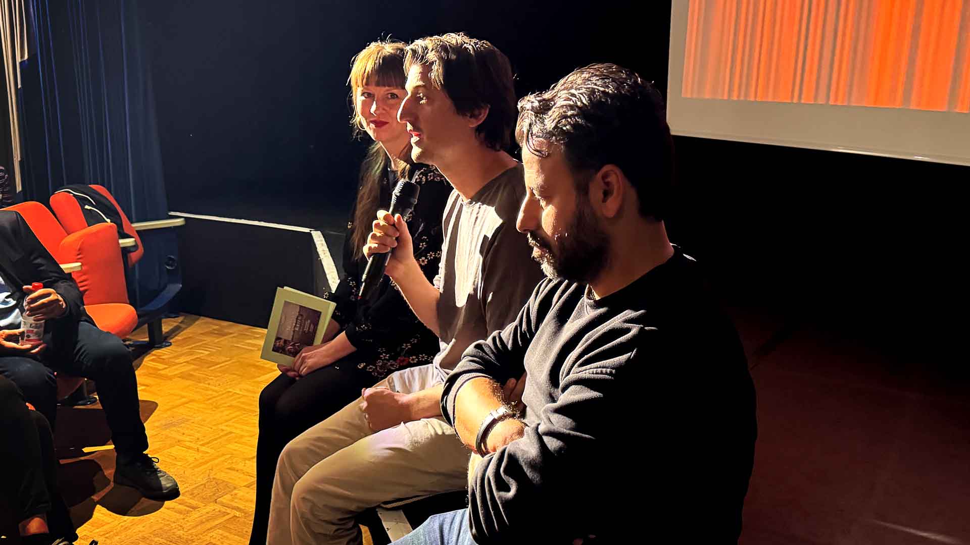 Dr. Marina Böddeker, Nicolas Ehret und Hüseyin Tabak auf deer Bühne des Kleinen Kinos am Weingarten